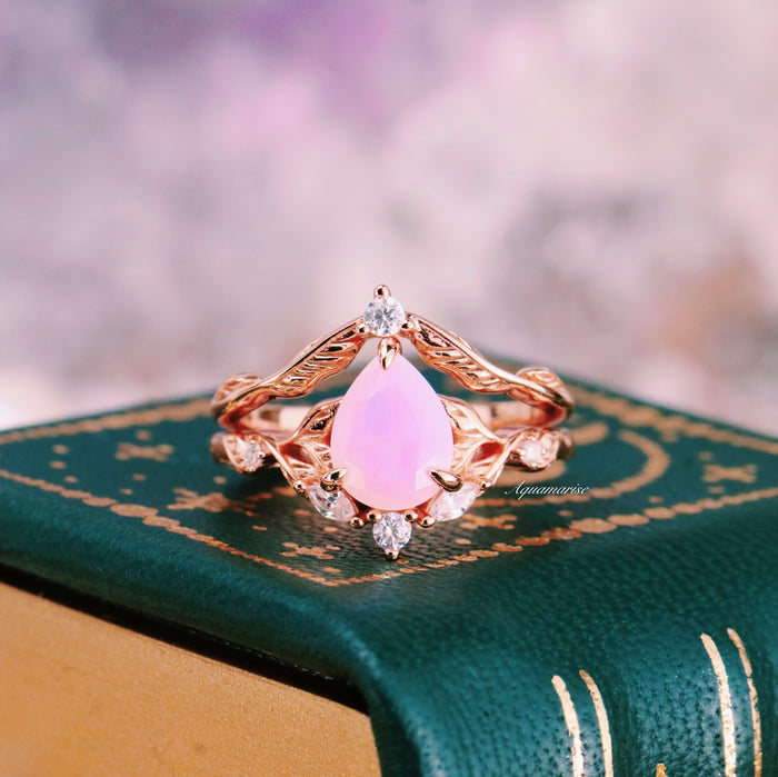 Opalescent Pink Sapphire Engagement Ring Set in 14K Rose Gold Vermeil by Aquamarise featuring a pear-shaped pink sapphire with diamond accents on an ornate rose gold band.