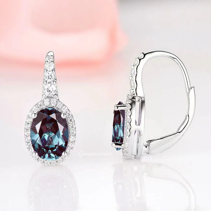 Oval Alexandrite Dangle Earrings in Sterling Silver by Aquamarise, featuring a radiant color-changing oval alexandrite surrounded by sparkling diamonds on a polished silver setting.