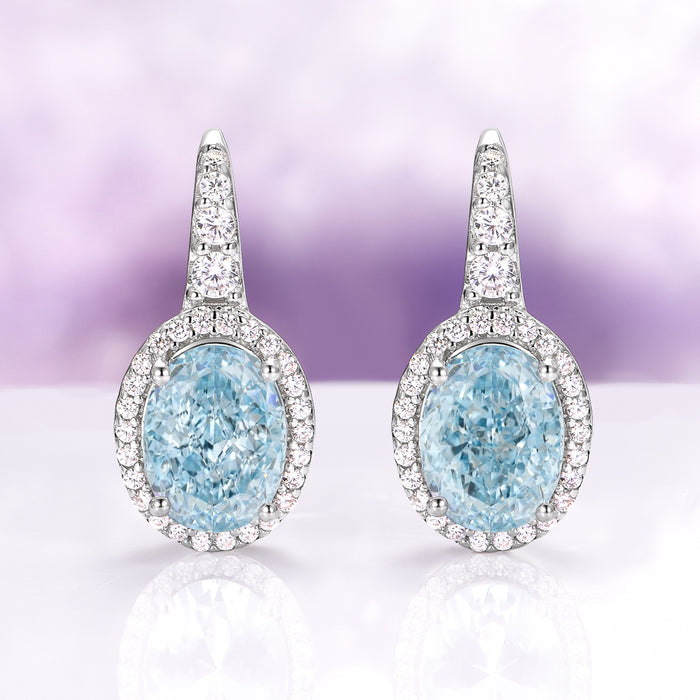 Oval Aquamarine Drop Earrings in Sterling Silver by Aquamarise, featuring sparkling oval aquamarine stones framed by shimmering simulated diamonds on polished sterling silver settings.