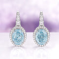 Oval Aquamarine Drop Earrings in Sterling Silver by Aquamarise, featuring sparkling oval aquamarine stones framed by shimmering simulated diamonds on polished sterling silver settings.