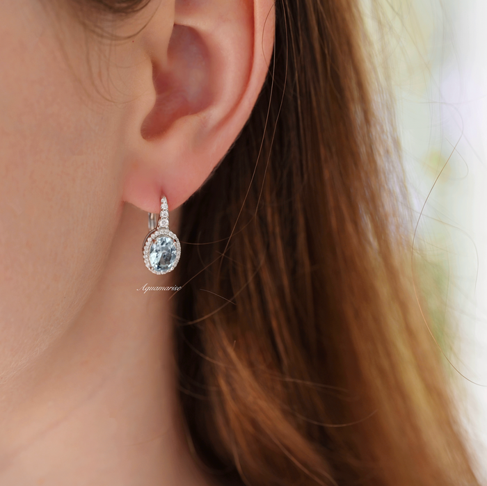 Oval Aquamarine Drop Earrings in Sterling Silver by Aquamarise, showcasing oval aquamarine stones encircled by sparkling simulated diamonds on polished sterling silver settings.