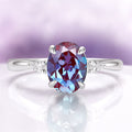 Oval Cut Alexandrite Engagement Ring in Sterling Silver by Aquamarise, featuring a color-shifting teal to violet oval alexandrite center stone, accented with pear-shaped clear gemstones on a polished sterling silver band, perfect for Sterling Silver Rings, June Birthstone Jewelry, Engagement Rings for Women, and Unique Engagement Rings collections.