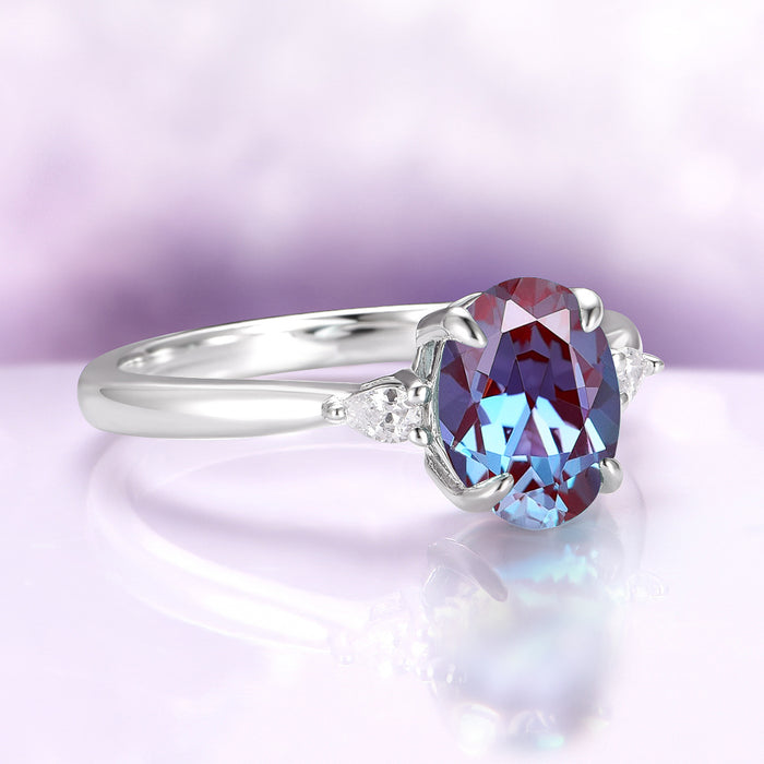Oval Cut Alexandrite Engagement Ring in Sterling Silver by Aquamarise featuring a vibrant oval-cut color-changing alexandrite center stone accented by pear-shaped clear gemstones on a polished sterling silver band, ideal for Sterling Silver Rings, June Birthstone Jewelry, Engagement Rings for Women, and Unique Engagement Rings collections.