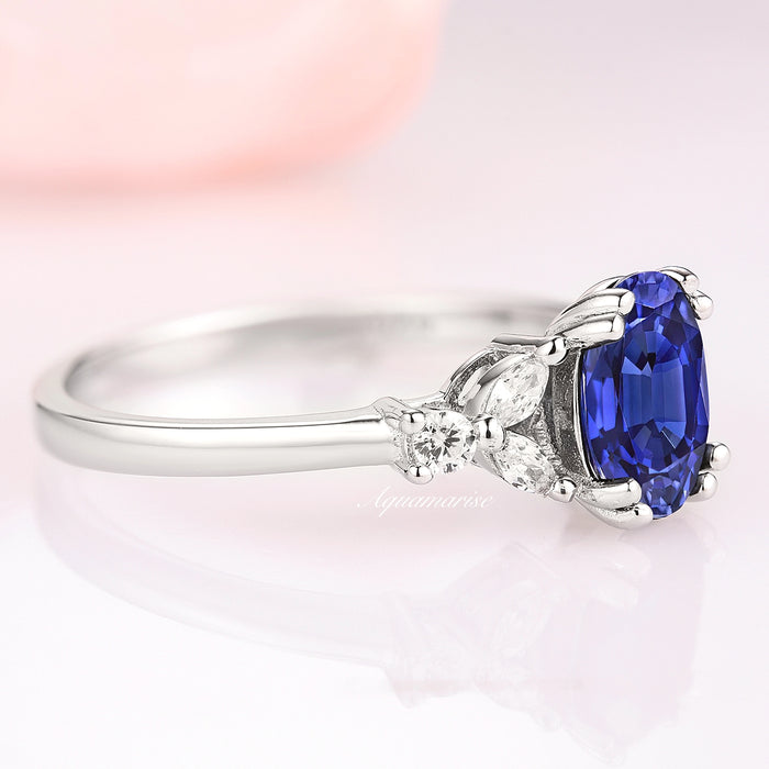 Oval Cut Blue Sapphire Engagement Ring in Sterling Silver by Aquamarise featuring a rich blue oval sapphire accented with delicate pear and round diamonds on a slender polished band.