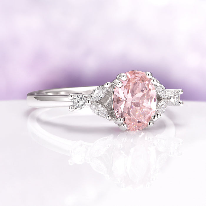 Oval Cut Blush Pink Morganite Ring in Sterling Silver by Aquamarise featuring an oval peachy-pink center stone accented with delicate leaf-shaped side stones on a polished band.