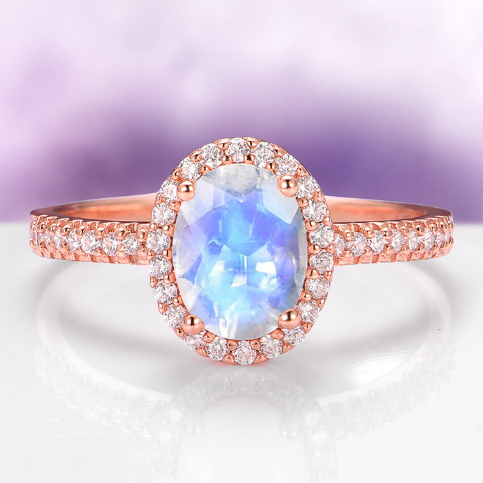 Galaxy Rainbow Moonstone Couples Ring Set featuring a luminous blue moonstone center with a sparkling diamond halo and pavé diamonds on a radiant rose gold band by Aquamarise.