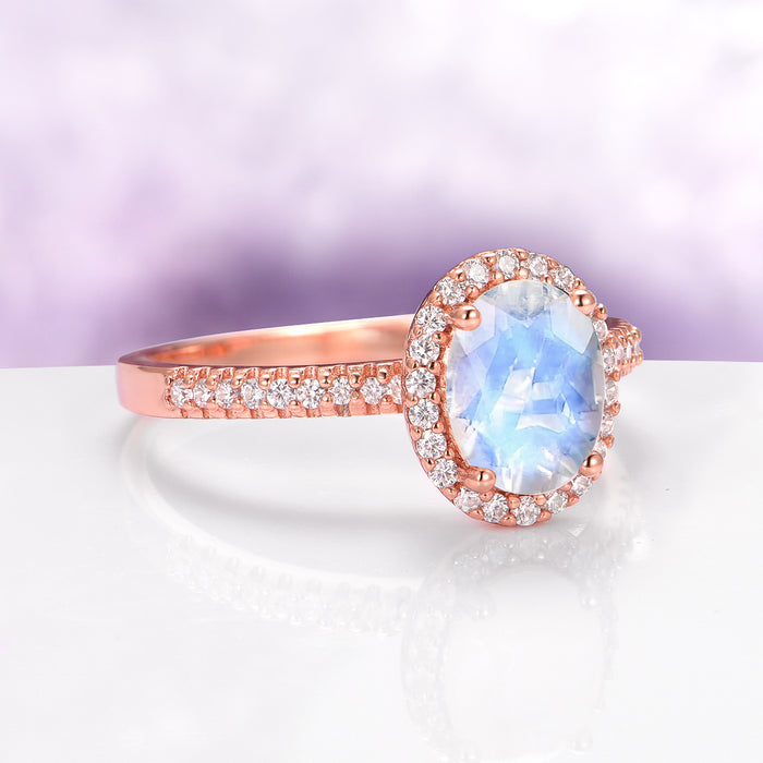Galaxy Rainbow Moonstone Couples Ring Set by Aquamarise, featuring an oval moonstone with glowing blue flashes, surrounded by sparkling diamonds on a rose gold band for matching couples' rings.