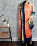 Peach Katan silk suit set with a dark blue border and a contrast dark blue dupatta, hand block printed with repeating circular geometric motifs in gold and yellow.