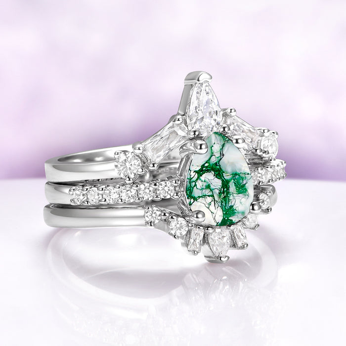 Pear Green Moss Agate Three-Piece Bridal Ring Set in Sterling Silver featuring a pear-shaped moss agate center with diamond accents by Aquamarise on a soft lavender background.