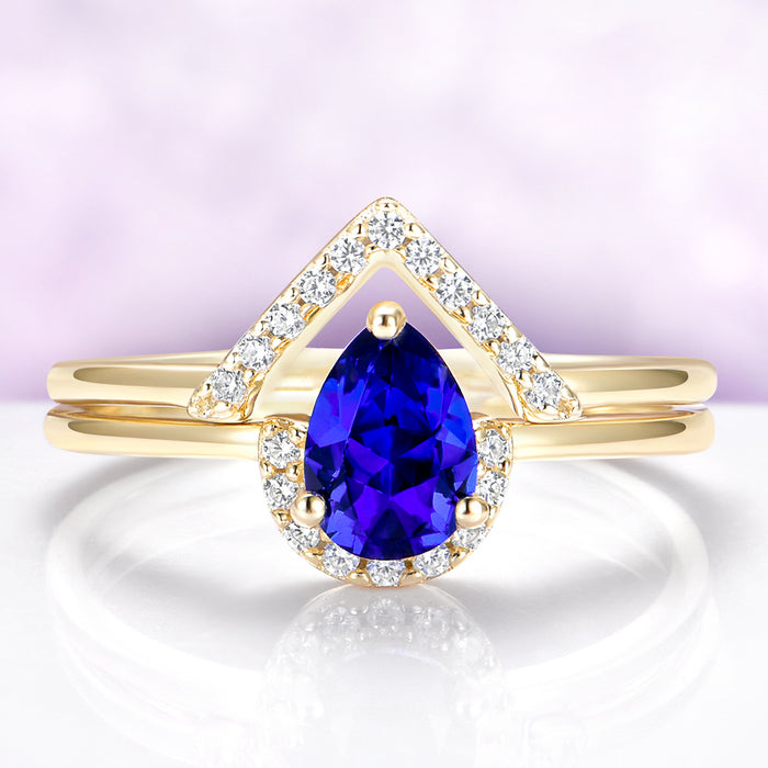 Gold ring with a blue gemstone and diamond accents on a light purple background