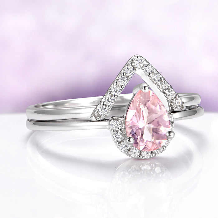 Silver ring with a pink teardrop-shaped gemstone on a light purple background