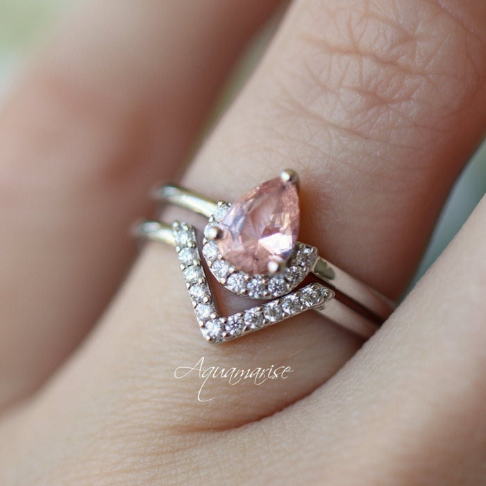 Two silver rings with pink gemstones on a person's finger, branded 'Aquamarise'.