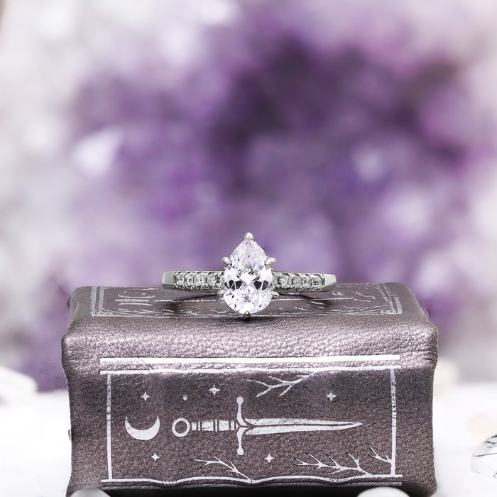 Pear White Sapphire Art Deco Bridal Ring Set in Sterling Silver by Aquamarise, featuring a pear-shaped white sapphire with delicate accent stones on an art deco-inspired sterling silver band.