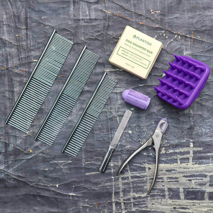 Pet grooming kit including combs, dog shampoo bar, grooming brush, and clippers for dogs and cats.
