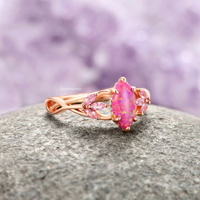 Pink Fire Opal & Sapphire Celtic Knot Ring- 14K Rose Gold Vermeil featuring a marquise pink fire opal center with delicate simulated pink sapphire accents on an intertwined rose gold band by Aquamarise, crafted from nature-inspired and fantasy engagement collections.
