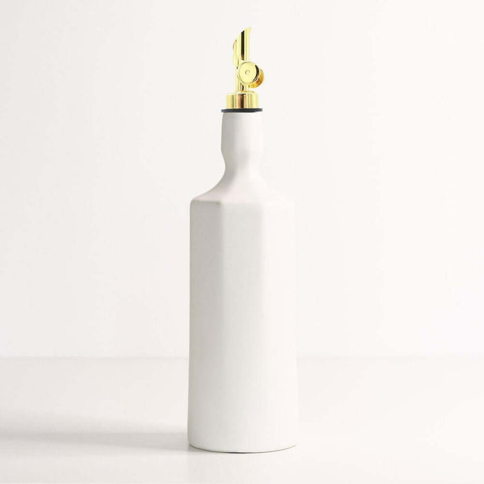 Handcrafted porcelain olive oil dispenser in white with a golden spout, perfect for kitchen use.