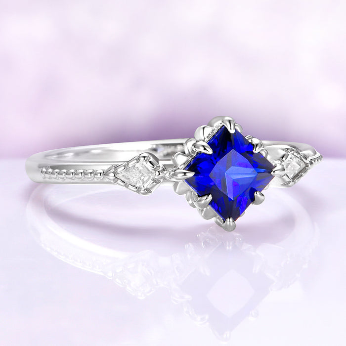 Silver ring with a blue gemstone on a light purple background