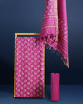 Fuchsia purple katan silk unstitched suit set with all-over white and pale gold floral hand block print, and a dupatta with striped ends and decorative fringe.