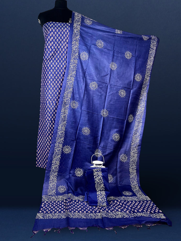 Purple katan silk unstitched suit set hand block printed with small off-white and pale pink botanical motifs, with a panelled dupatta ending in a short self fringe.