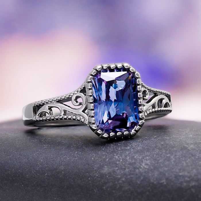 Radiant Cut Alexandrite Engagement Ring in Black Ruthenium by Aquamarise, featuring an ornate band with vintage scrollwork and a striking color-changing radiant cut alexandrite center stone.