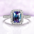 Radiant Cut Halo Alexandrite Ring in Sterling Silver by Aquamarise, featuring a vibrant purple-blue gemstone surrounded by sparkling silver pavé diamonds on the band and halo.