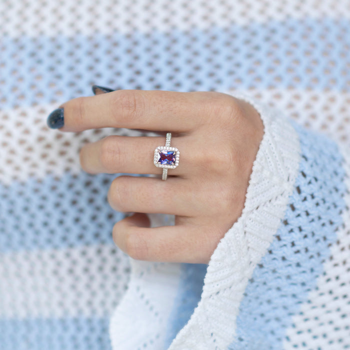 Rae Alexandrite Ring- Sterling Silver by Aquamarise featuring a radiant emerald cut alexandrite center stone surrounded by sparkling simulated diamonds on a delicate sterling silver band.