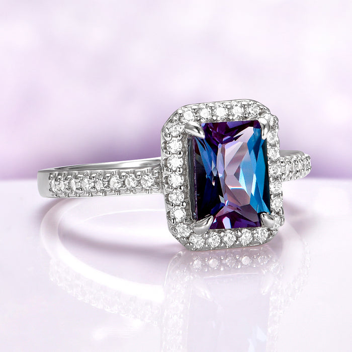 Radiant Cut Halo Alexandrite Ring in Sterling Silver featuring a rectangular multicolor gemstone surrounded by small diamonds on a polished silver band by Aquamarise.