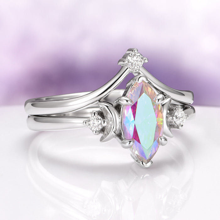 Rainbow Moissanite Crescent Moon Engagement Ring Set in Sterling Silver by Aquamarise Gold, featuring a marquise-cut rainbow moissanite center stone with pastel violet, blue, and gold flashes, accented by crescent moon motifs and small white gemstones, part of Sterling Silver Rings, Engagement Rings for Women, and Moissanite Engagement Rings collections.
