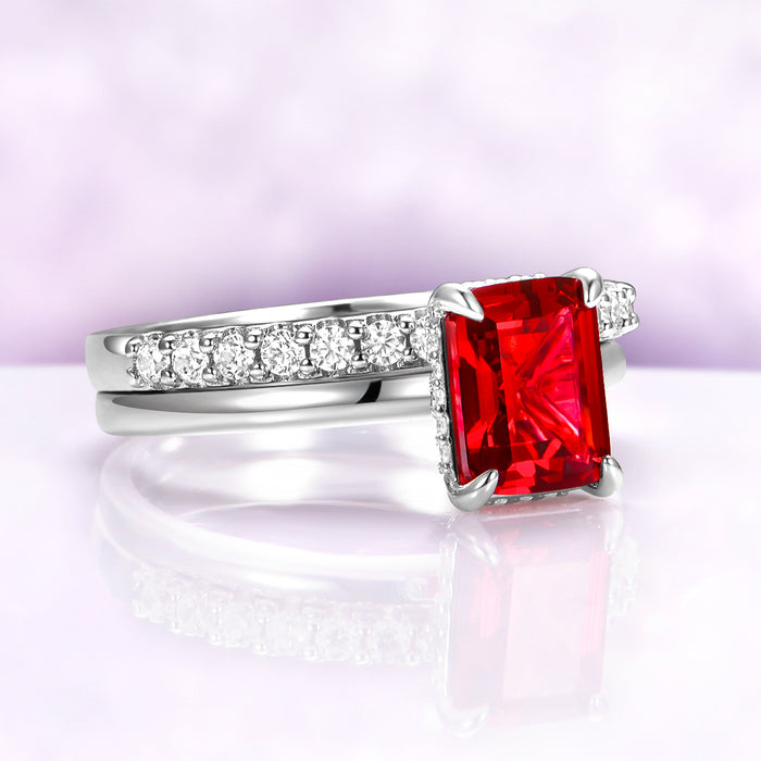 Raspberry Tourmaline Solitaire Engagement Ring in Sterling Silver by Aquamarise, featuring a radiant red emerald-cut gemstone with diamond accents on a polished band.