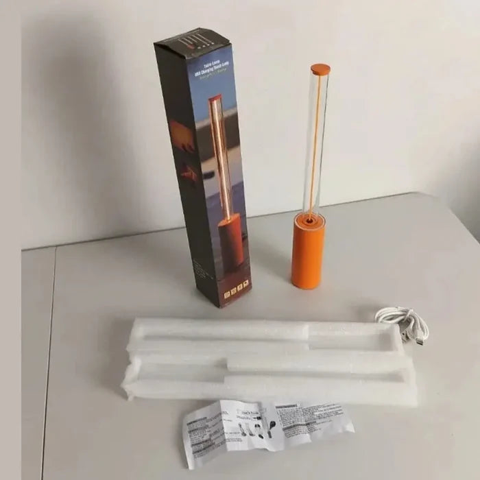 Rechargeable LED night light with packaging and accessories on a table.