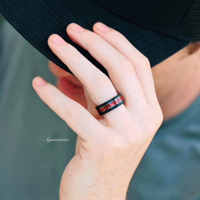 Red Garnet Wedding Band in Two Tone Tungsten Carbide (8mm) by Aquamarise worn on a hand, featuring a black band with crushed red garnet inlay, ideal for men’s rings and January birthstone jewelry.