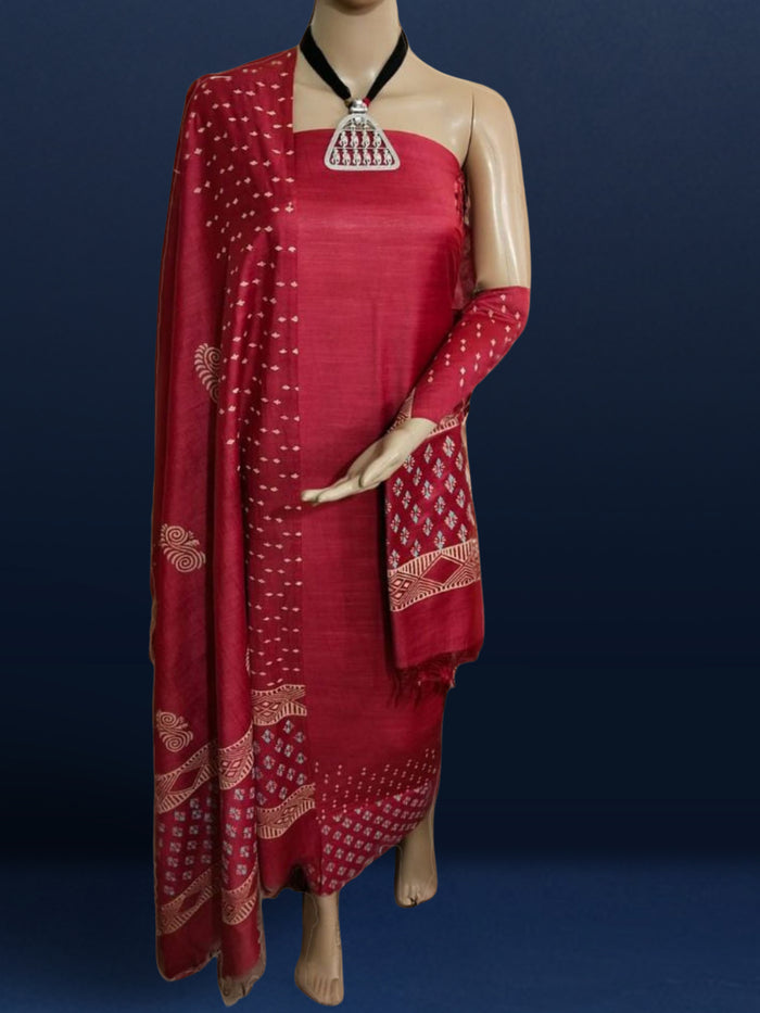 Bright red katan silk unstitched suit set hand block printed with small angular teal and off-white sprigs and geometric bands at the ends of the length.