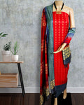 Red Katan silk suit set hand block printed in panels of circles, zigzags and vertical stripes with dark grey and teal sections, gold accents and a banded dupatta hem.