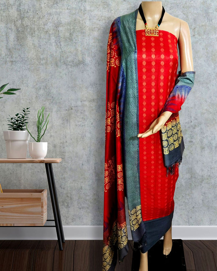 Red Katan silk suit set hand block printed in panels of circles, zigzags and vertical stripes with dark grey and teal sections, gold accents and a banded dupatta hem.