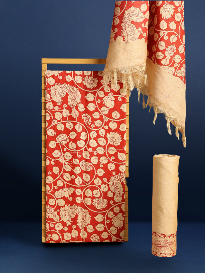 Red Katan silk unstitched suit set hand block printed with cream peacocks and floral vines in an all-over repeat, with a fringed dupatta and a horizontal patterned band on the bottom piece.