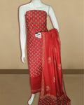 Vivid red katan silk unstitched suit set hand block printed with upright teal and pale gold tulip motifs, with a dupatta framed by an intricate floral border.