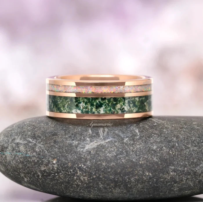 Moss Agate & Fire Opal Couples Ring Set by Aquamarise featuring rose gold band with green moss agate and shimmering opal inlay, showcased on a smooth stone for Matching Couples' Rings collection.