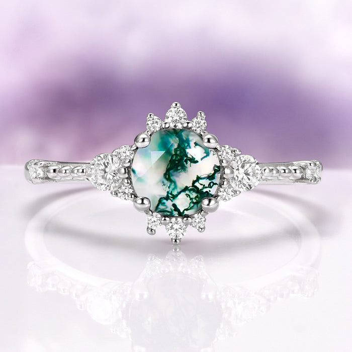 Round Green Moss Agate Ring in Sterling Silver by Aquamarise featuring a round natural green moss agate center with intricate leaf-inspired diamond accents on a polished band.