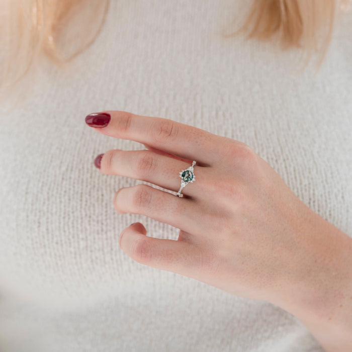 Round Green Moss Agate Ring in Sterling Silver by Aquamarise featuring a natural green moss agate center with delicate leaf-inspired details worn on a hand with burgundy nails and a cream sweater.