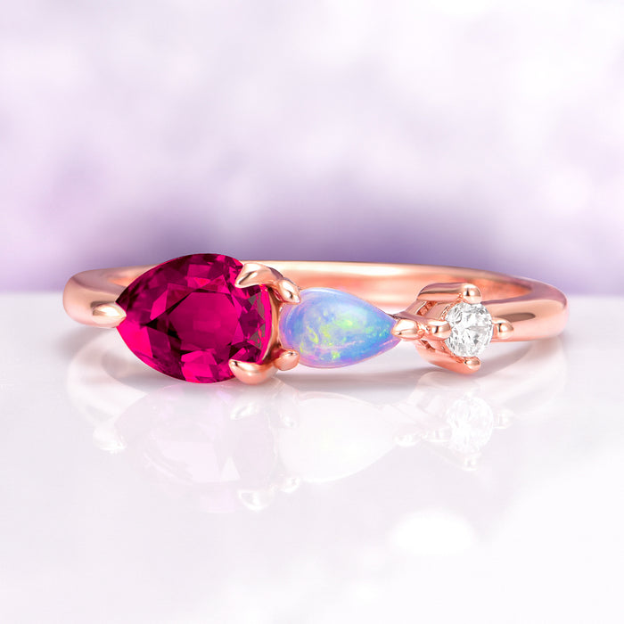 Lab Grown Ruby and Natural Australian Opal Engagement Ring in 14K Solid Rose Gold by Aquamarise Gold featuring a pear cut ruby, Australian opal, and moissanite accents on a delicate rose gold band.