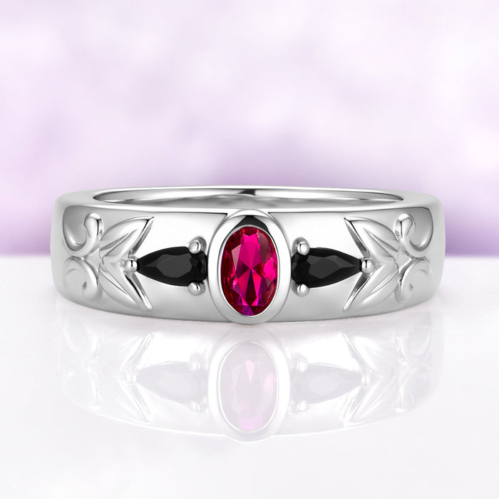 Men's 6mm sterling silver wedding band with a bezel-set oval lab-grown ruby between two black onyx pears and carved leaf shoulders