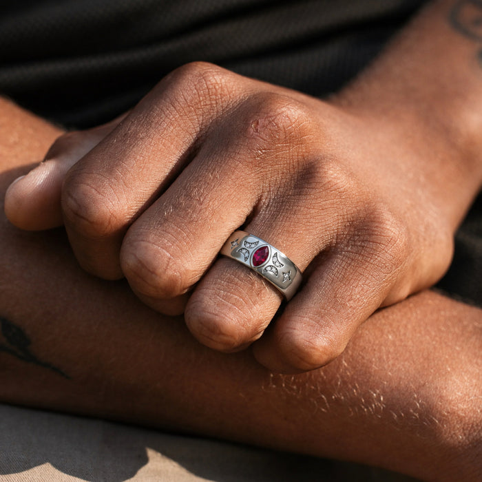 Man wearing the 6mm Ruby Celestial wedding band, bezel-set marquise ruby flanked by pave crescent moons and four-point star accents