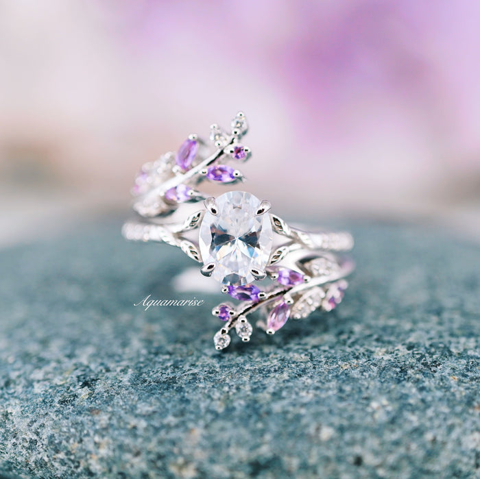 Simulated Diamond & Amethyst Leaf Couples Ring Set featuring an elegant silver band with an oval simulated diamond centerpiece surrounded by delicate amethyst leaf accents, crafted by Aquamarise as nature-inspired matching couples rings.