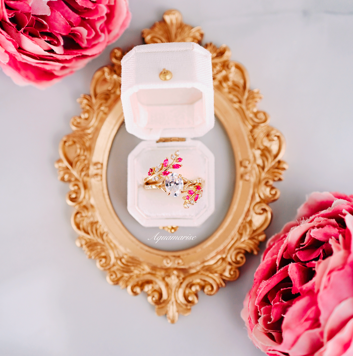 Simulated Diamond & Ruby Leaf Engagement Ring Set in 14K Yellow Gold Vermeil by Aquamarise displayed in a white velvet box on an ornate gold frame with pink floral accents.