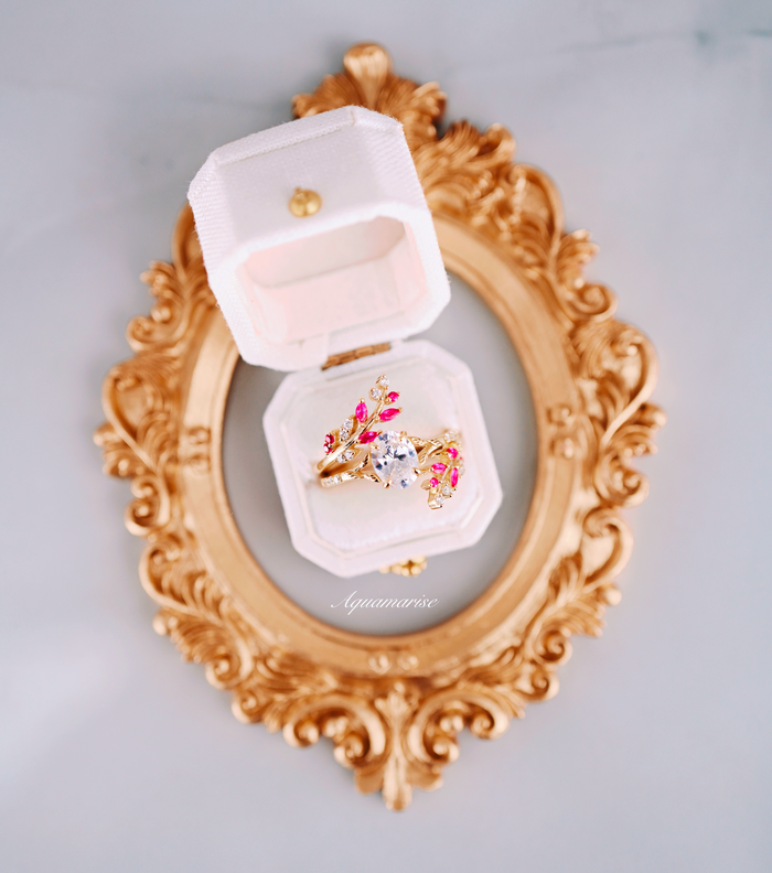 Simulated Diamond & Ruby Leaf Engagement Ring Set in 14K Yellow Gold Vermeil displayed in an elegant white velvet box atop a vintage gold ornate frame, showcasing vibrant ruby accents and intricate leaf design by Aquamarise.