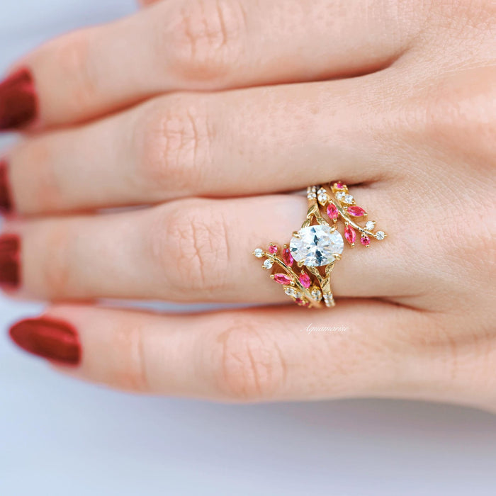 Lab-Grown Diamond Leaf Engagement Ring in 14K Solid Yellow Gold (IGI Certified) by Aquamarise Gold featuring a nature-inspired design with sparkling diamonds and vibrant pink gemstone accents on a delicate leaf motif, worn on a hand with red nail polish.