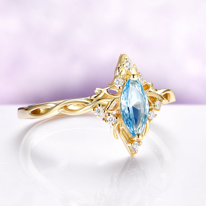 Siren Queen Marquise Aquamarine Lotus Engagement Ring in Solid 14K Yellow Gold featuring a marquise aquamarine surrounded by lotus-inspired gold and small sparkling diamonds.