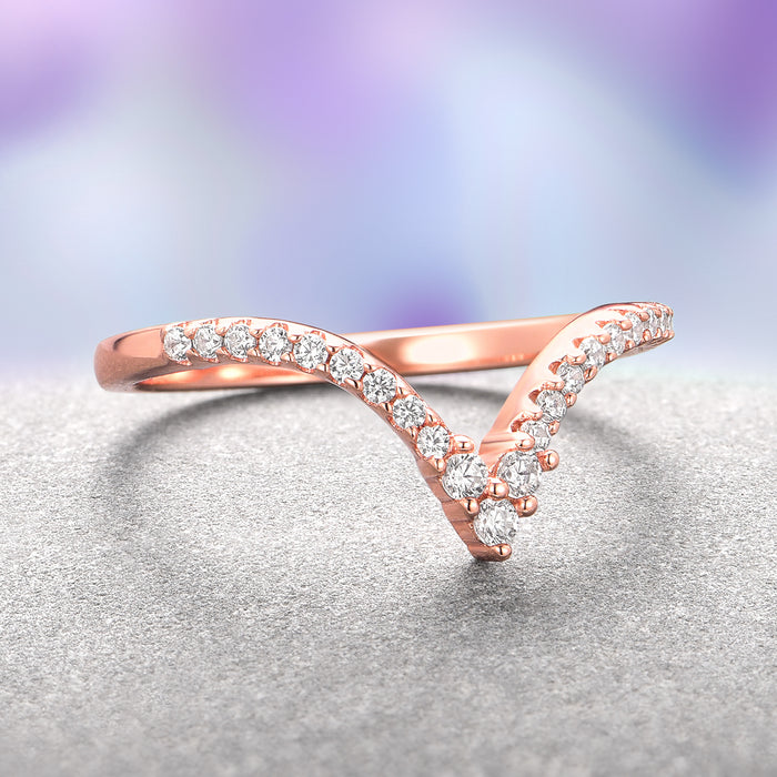 Skye Kite® Chevron Stacking Wedding Band in 14K Solid Rose Gold by Aquamarise Gold features a delicate V-shaped design set with petite sparkling moissanite stones, perfect for stacking with engagement rings.