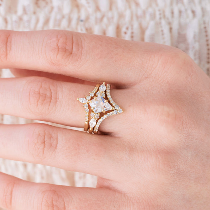 Yellow gold engagement ring set with kite cut diamond center stone and accents on hand over a light background
