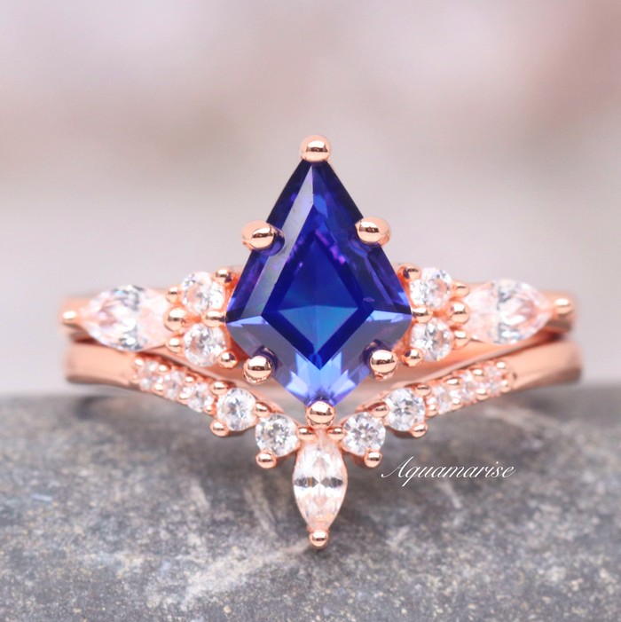 Skye Kite® Orion Nebula™ & Cornflower Sapphire Couples Ring Set featuring a deep blue sapphire center with rose gold bands and accent diamonds by Aquamarise.